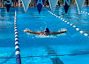 Swimmer mid-butterfly stroke in the competition pool