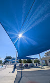 Blue shade structure over the patio lounge chairs