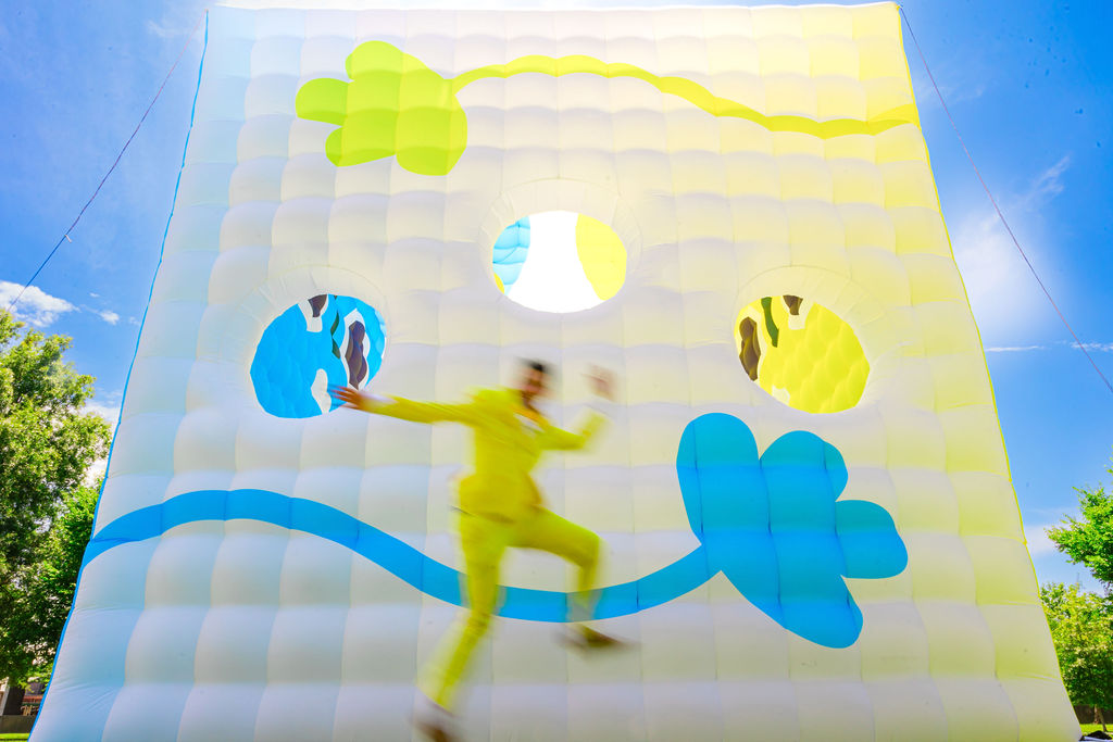 KEVPOP jumping in front of inflatable installation