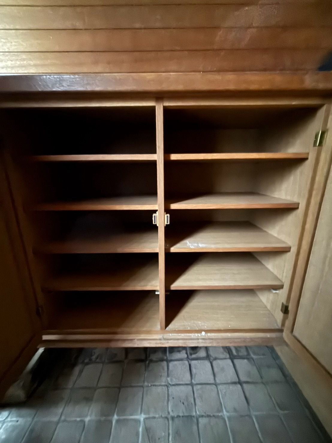 扉を開けた玄関の下駄箱。棚に靴や物は残っていない
