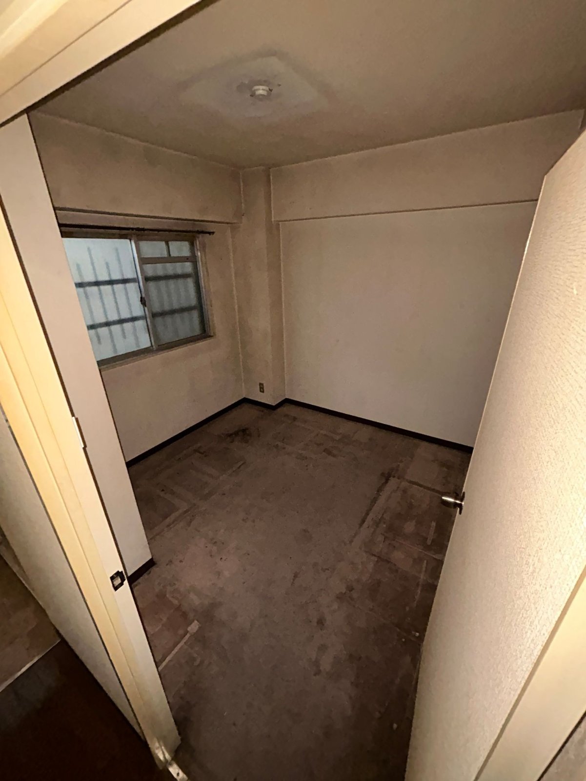 作業後のマンションの洋室。すりガラスの窓があり、床に物は残っていない