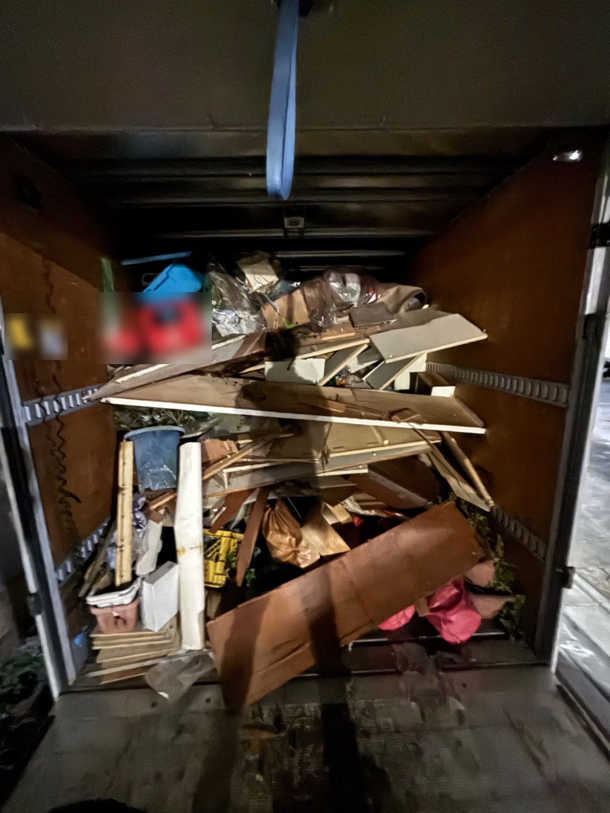 豊島区の一軒家から運び出した家財を積んだ箱型トラックの荷台。棚板のような板材、プラスチックのケース、袋などが積まれている