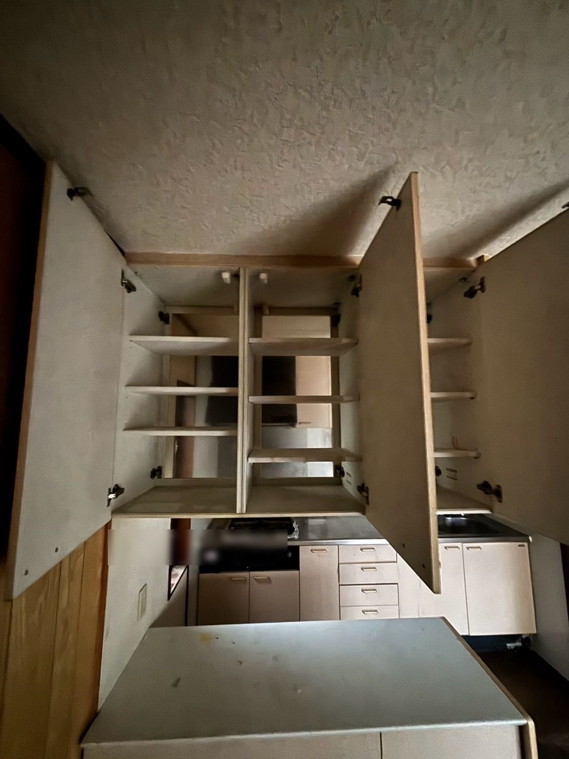 扉を開けた台所の吊り戸棚。棚に物は残っていない