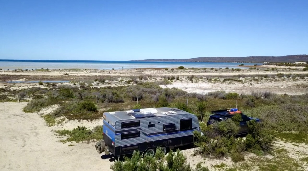 Our caravan and Patrol camped by the water