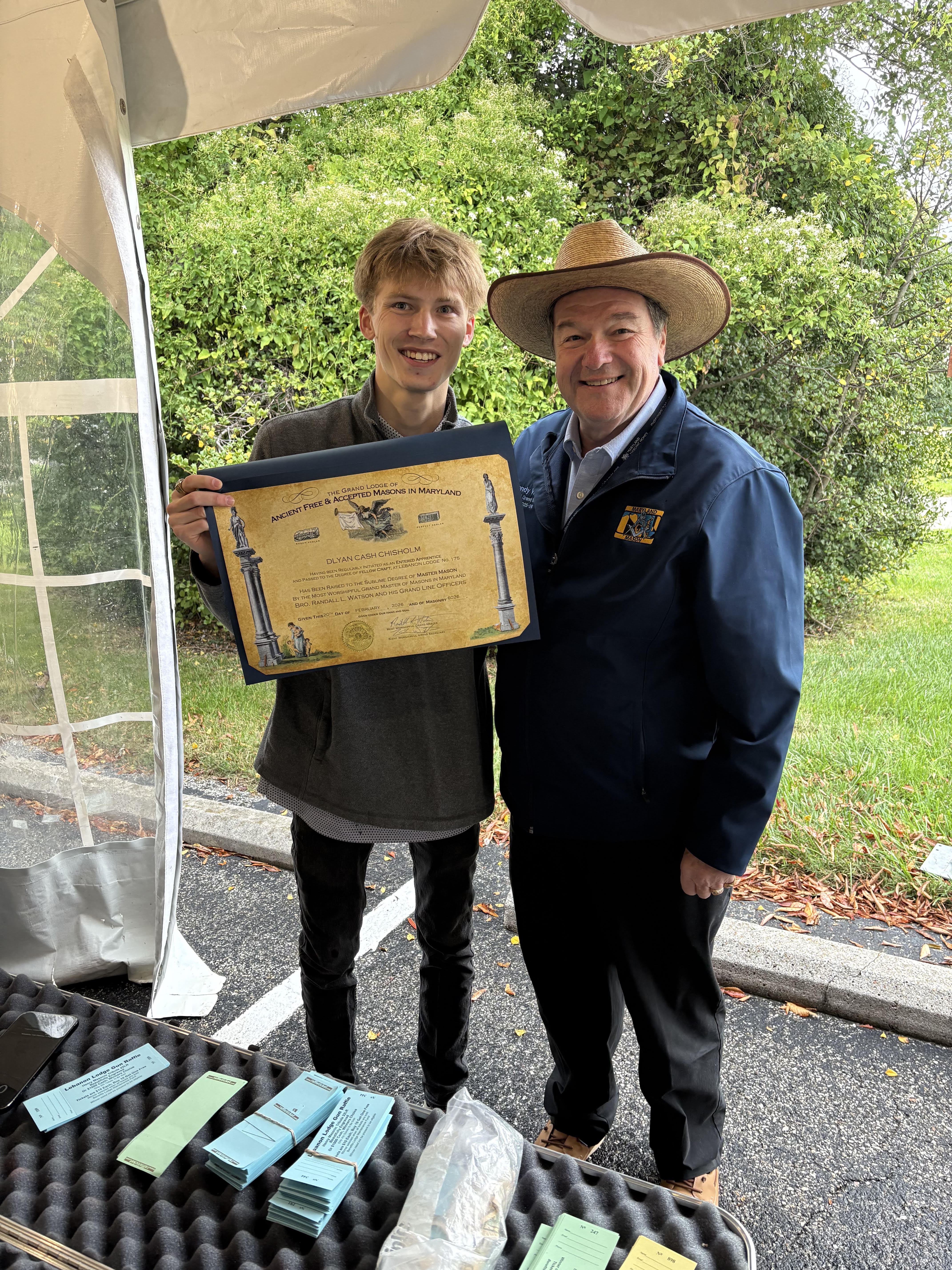 Brother Dlyan Chisholm holding his Master Mason certificate