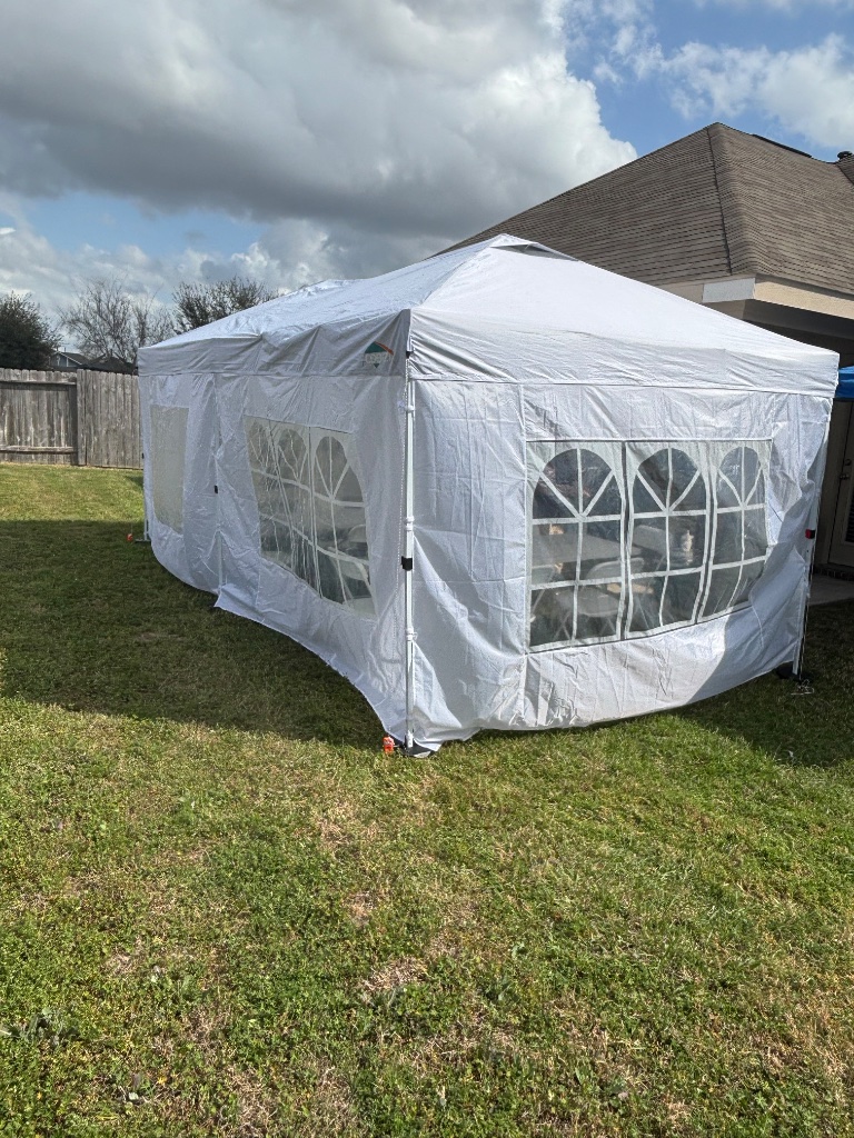 White frame tent with arched windows on green lawn 🌿