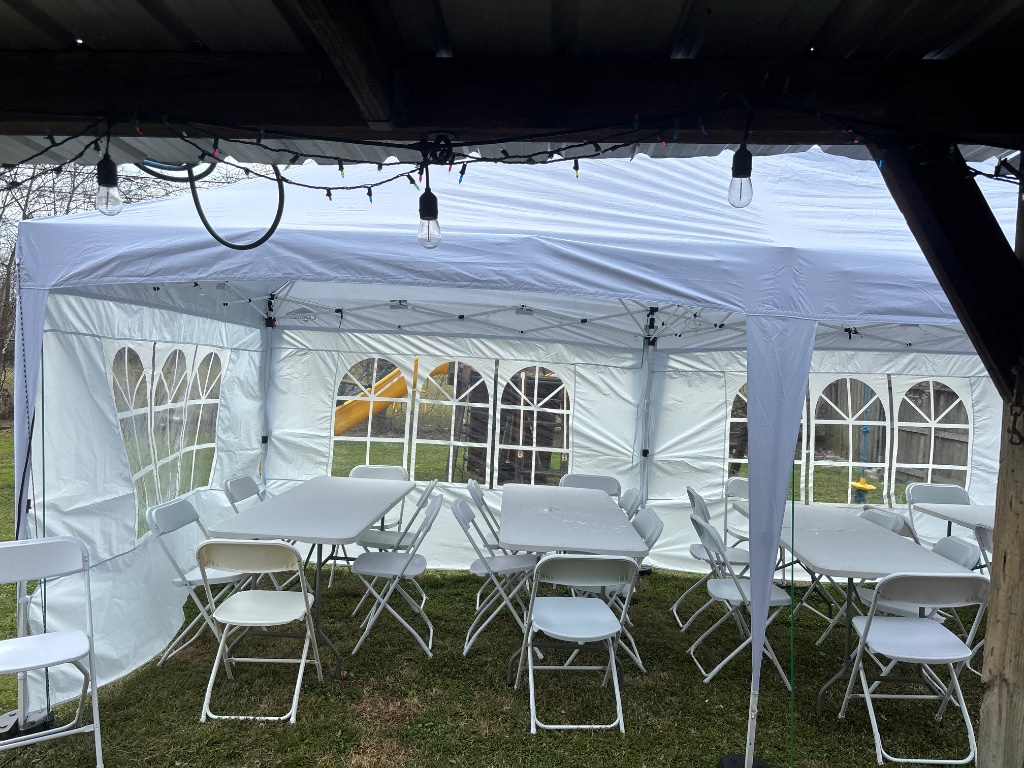 White canopy glowing with warm bistro lights at dusk 🌅