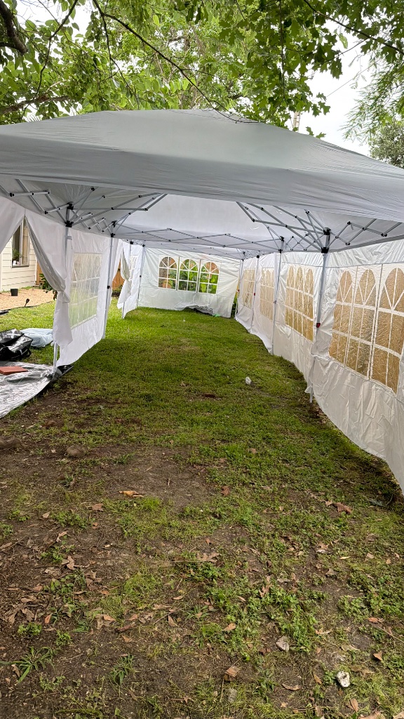White tent with window panels on lush lawn ⛺