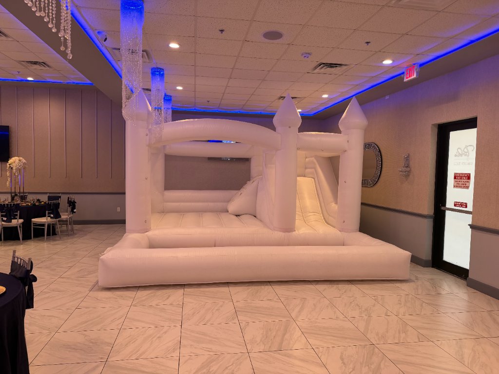 White bounce castle in luxury indoor venue — crystal chandeliers 💎