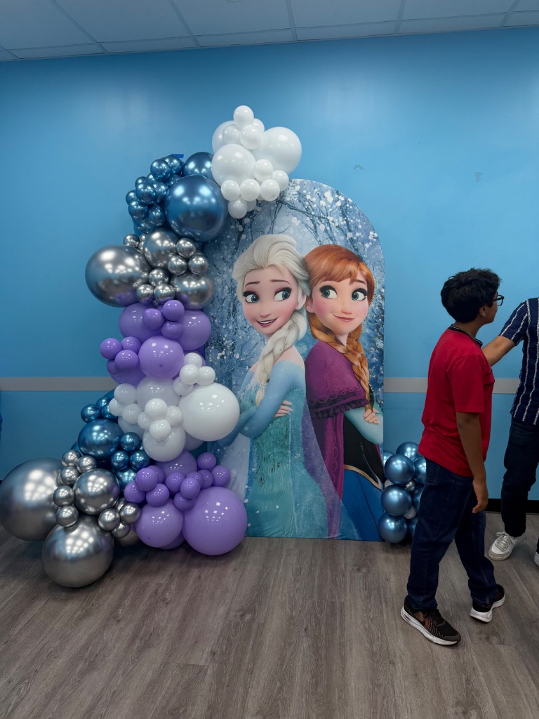 Frozen backdrop — Elsa & Anna with purple balloon garland ❄️