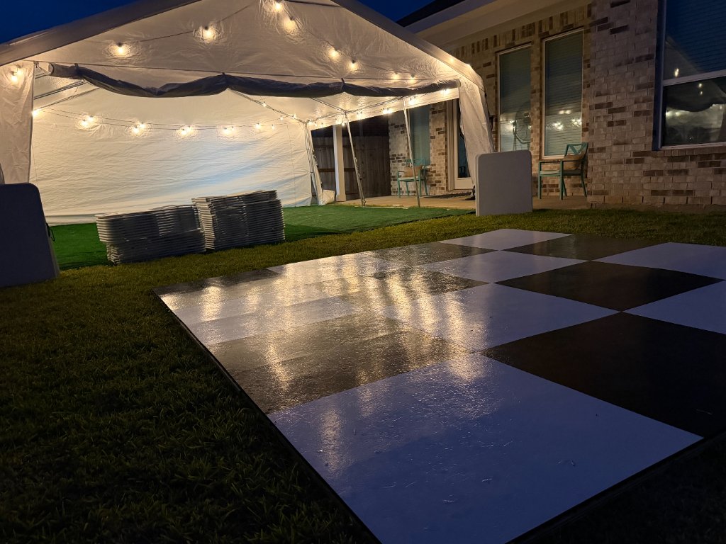 Checkered dance floor, turf & glowing bistro lights at twilight 🕺
