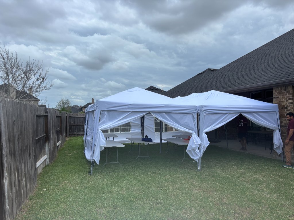 Twin white canopies flanking a bounce castle — chic setup 🤍