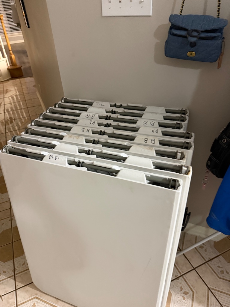 White folding tables — stacked & ready to roll 🪑