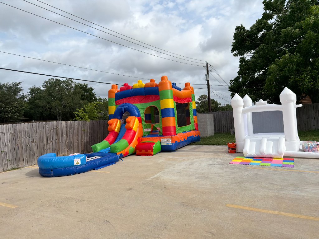 Colorful slide bounce house & white castle duo — double the fun 🎠