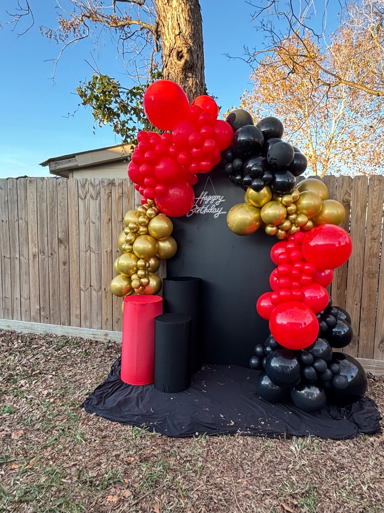 Red, black & gold organic arch — dramatic floor pedestals 🎉