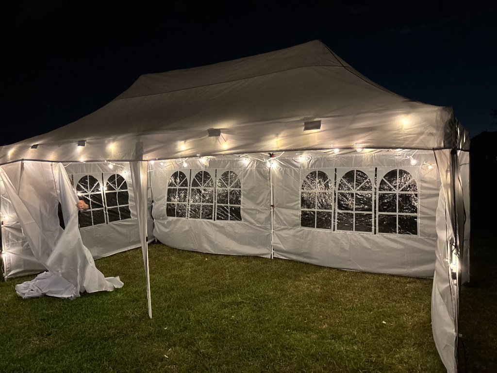 White tent with string lights — intimate evening venue 🕯️