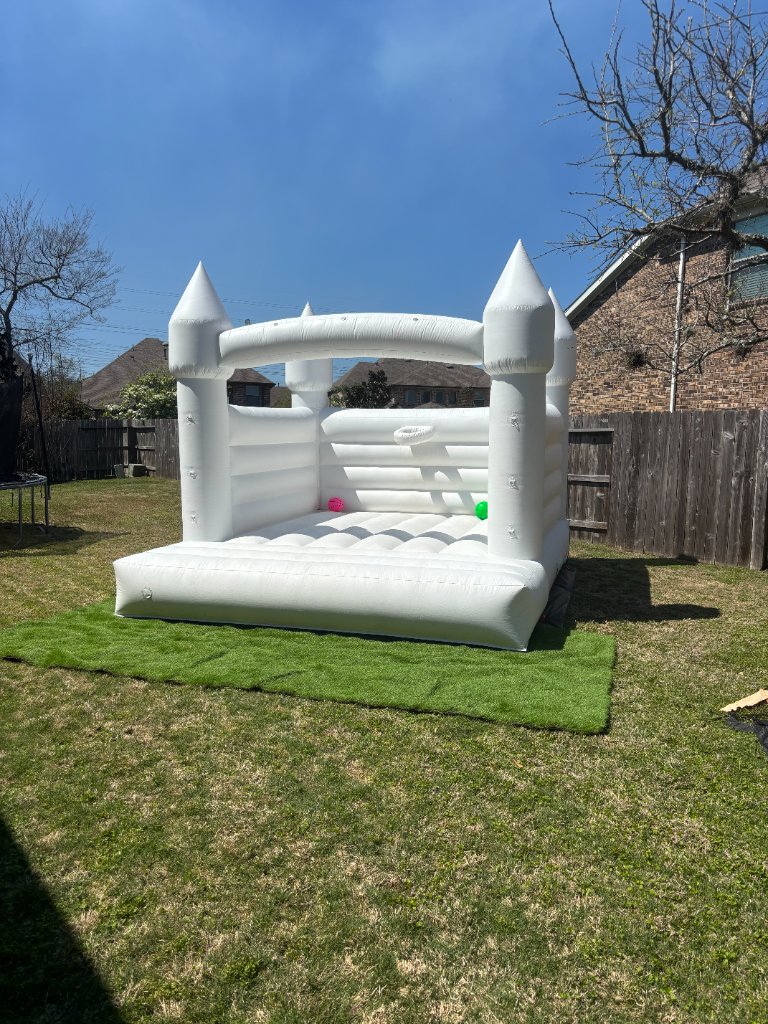 White bounce house on turf under a brilliant blue sky ☀️