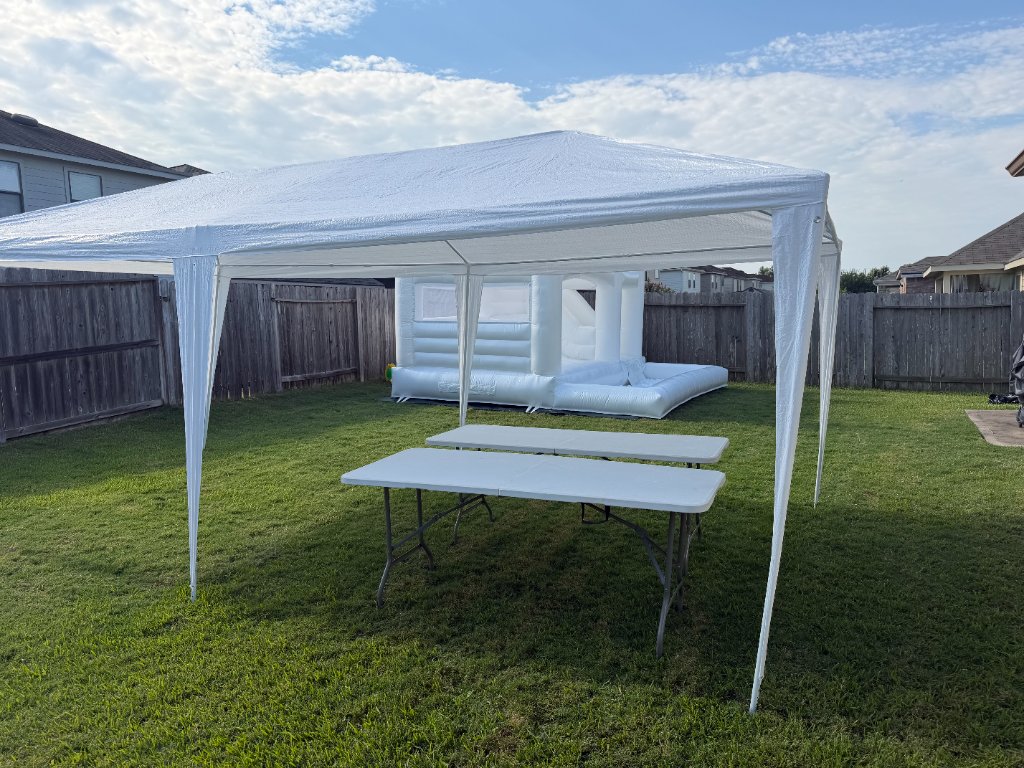 White tent with tables & bounce castle — full backyard setup ⛺