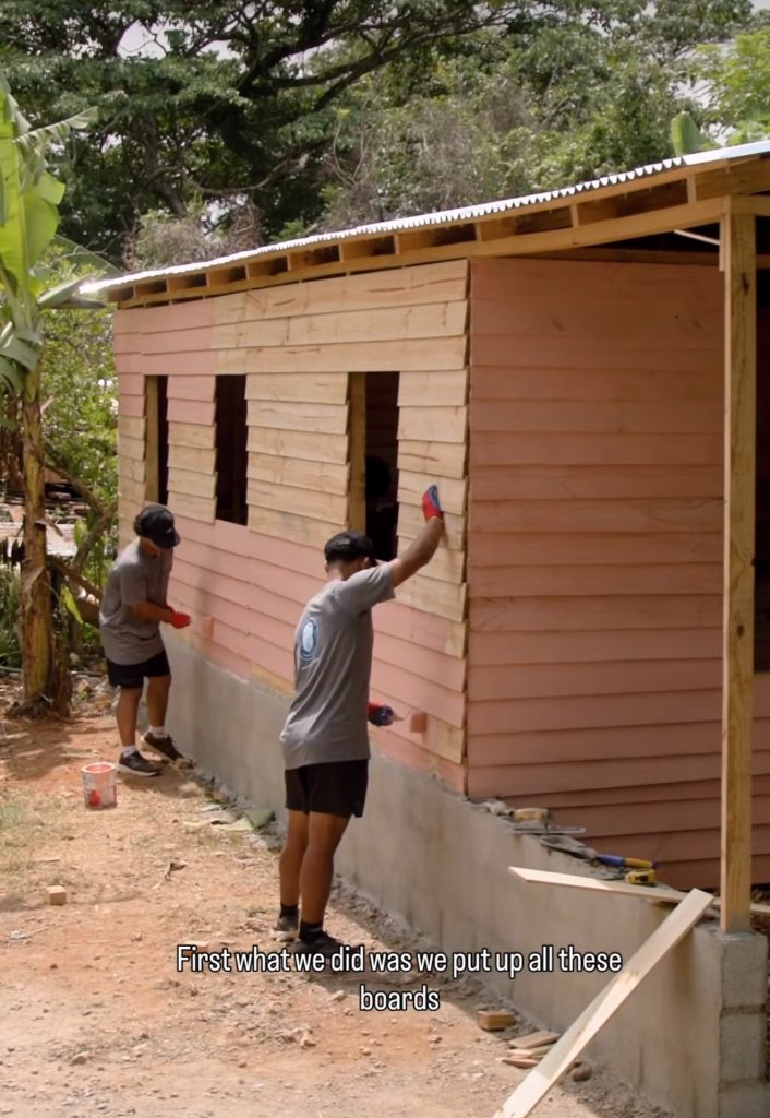 Players working on the exterior of a house