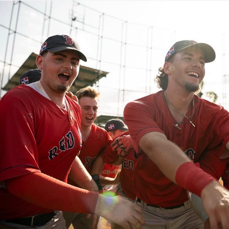 Three teammates laughing on the field