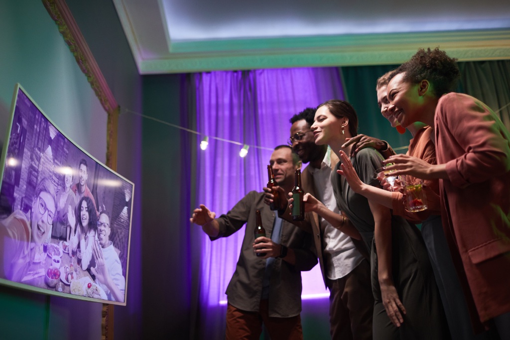 Young people reacting to photos on a screen at a party