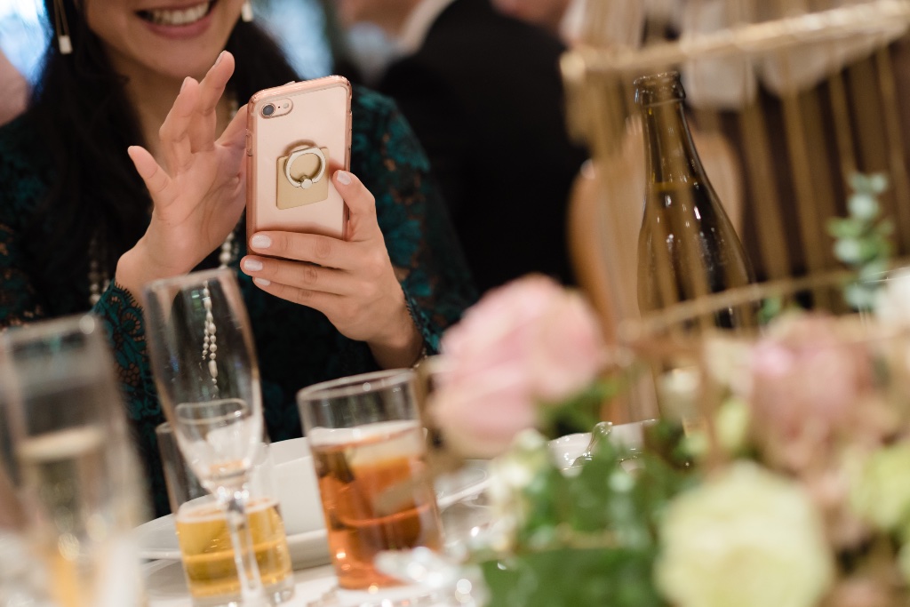 Woman looking at her phone at a wedding reception