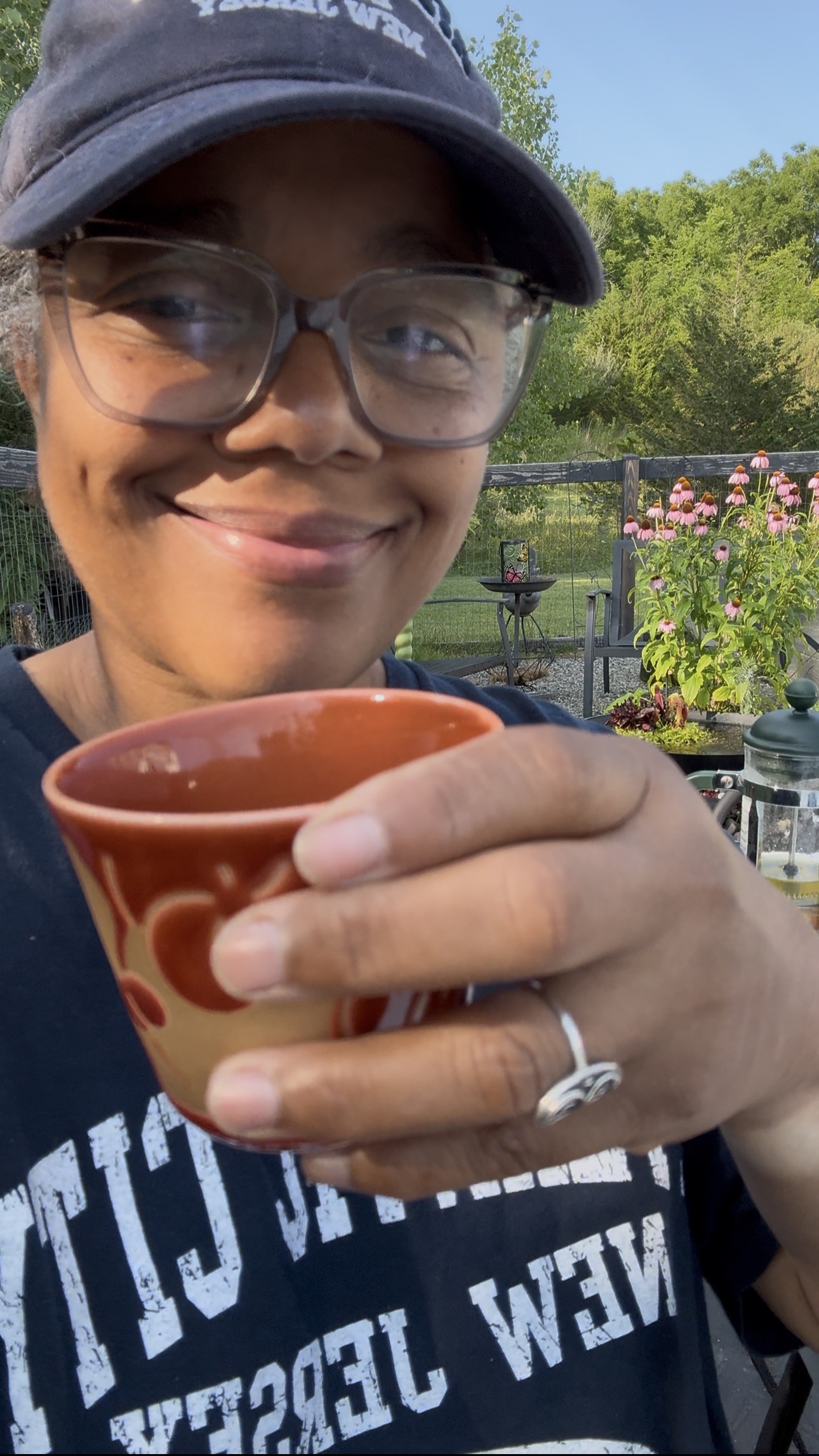Charmaine in her garden with a cup of tea