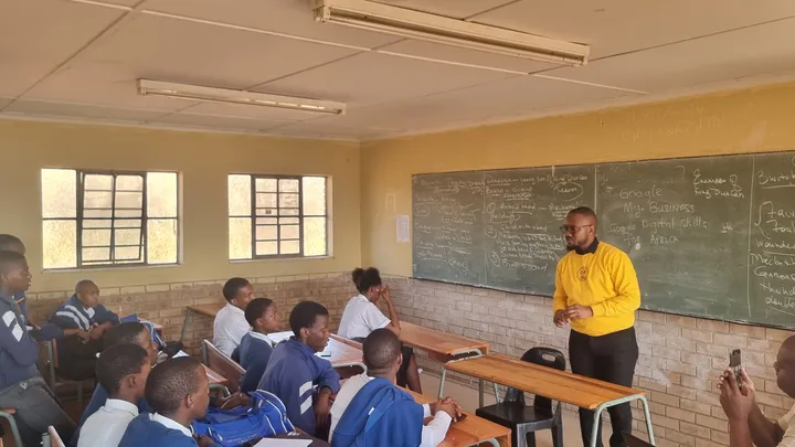 Awali Academy facilitator presenting digital skills to school learners