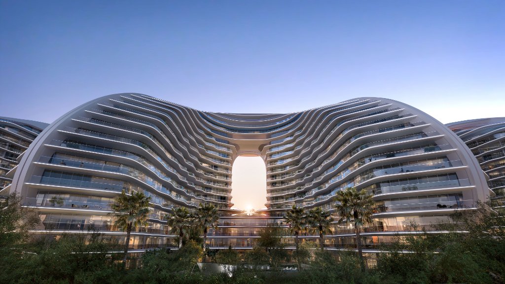 Architecture moderne et courbes fluides du complexe résidentiel Oystra par Richmind, vue extérieure en contre-plongée au crépuscule.