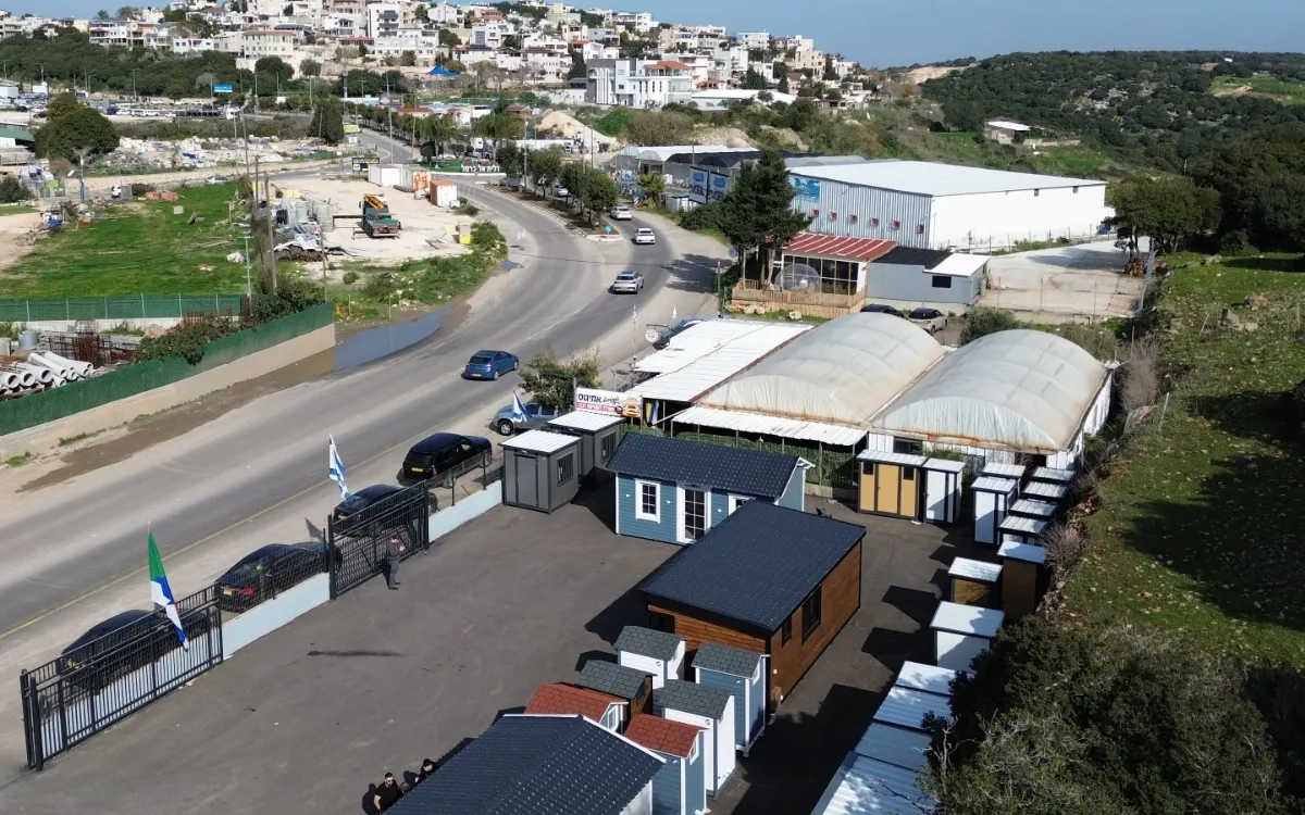 אולם התצוגה של נפסאק מהאוויר: מבנים לדוגמה במגרש ליד הכביש, ודאלית אל-כרמל ברקע