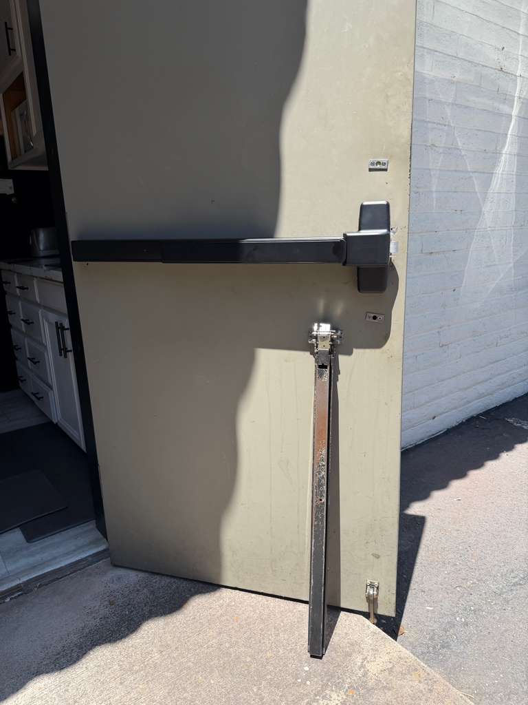 Commercial panic bar replacement on a metal door