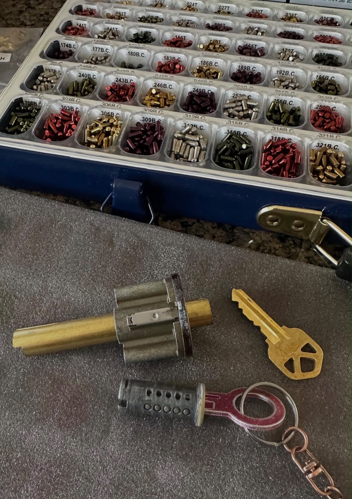 Lock rekeying kit with pins, cylinder, and freshly cut key