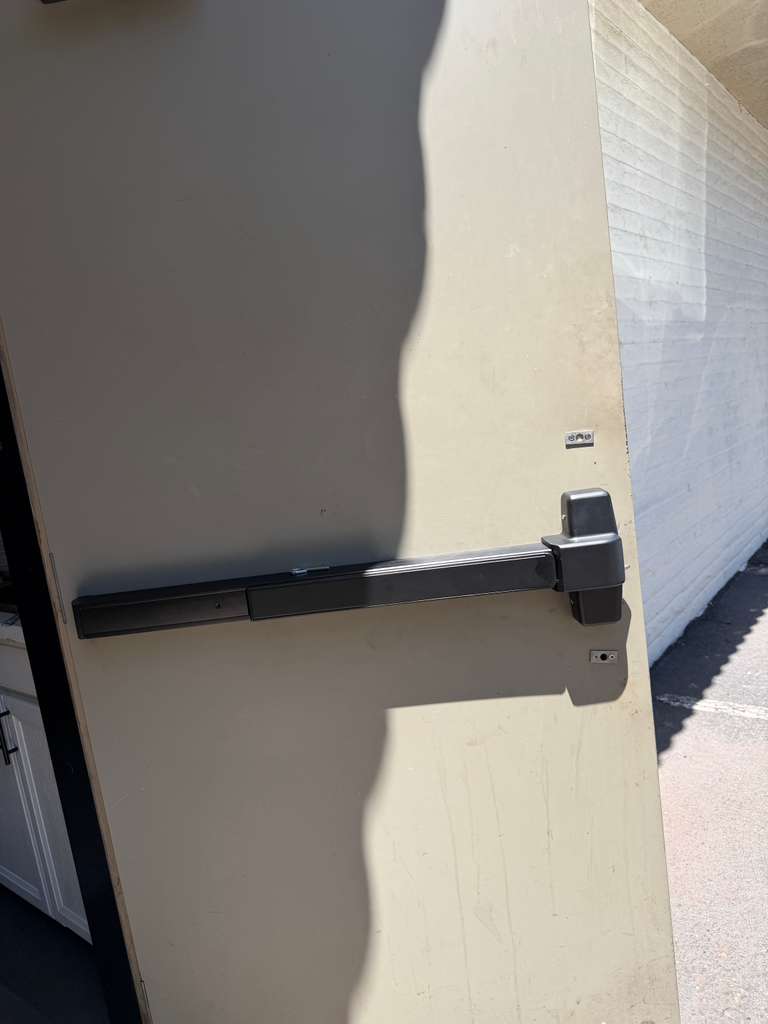 Commercial door with black horizontal panic bar installed