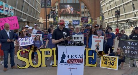 NHSC volunteer speaking at a podium at a rally