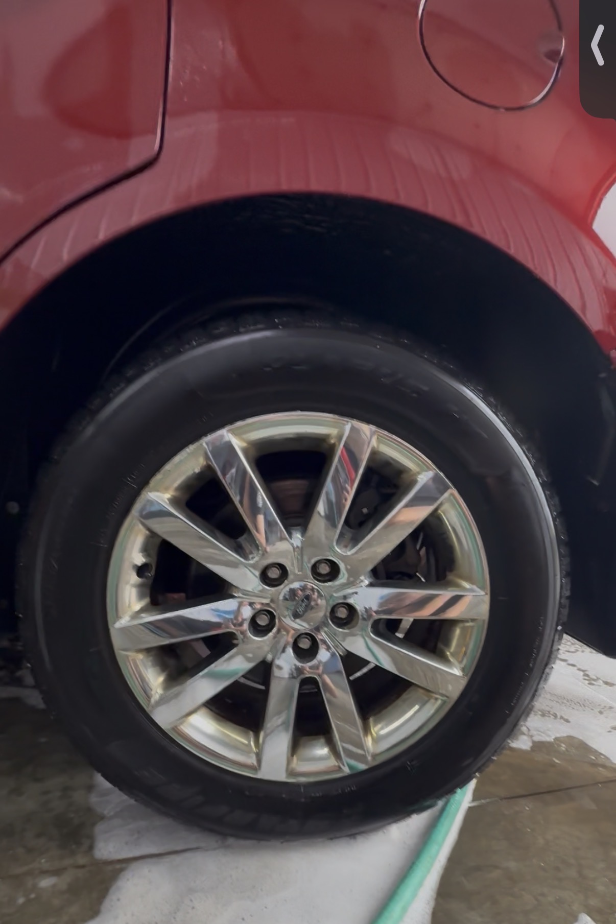 Cleaned chrome wheel on a red car