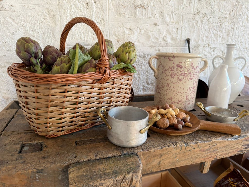 Rustic outdoor kitchen worktable with artichokes and ceramics