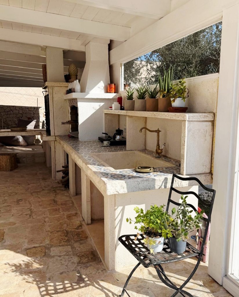 Outdoor kitchen with stone sink and wood-fired oven