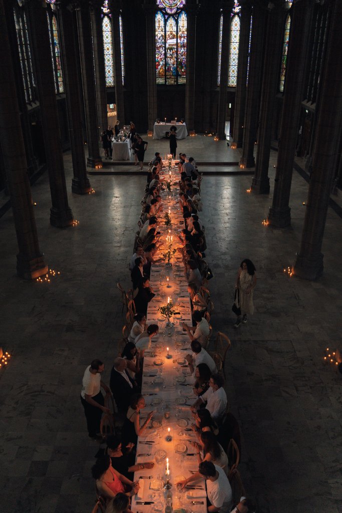 Longue table de banquet dressée dans une salle voûtée éclairée à la bougie — activation de marque culinaire MIVO
