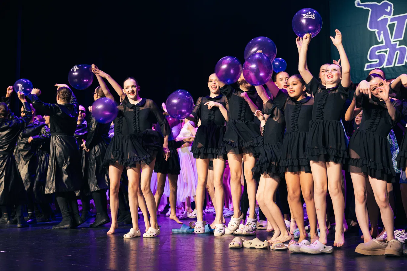 That's Showbiz dancers performing on stage with purple balloons
