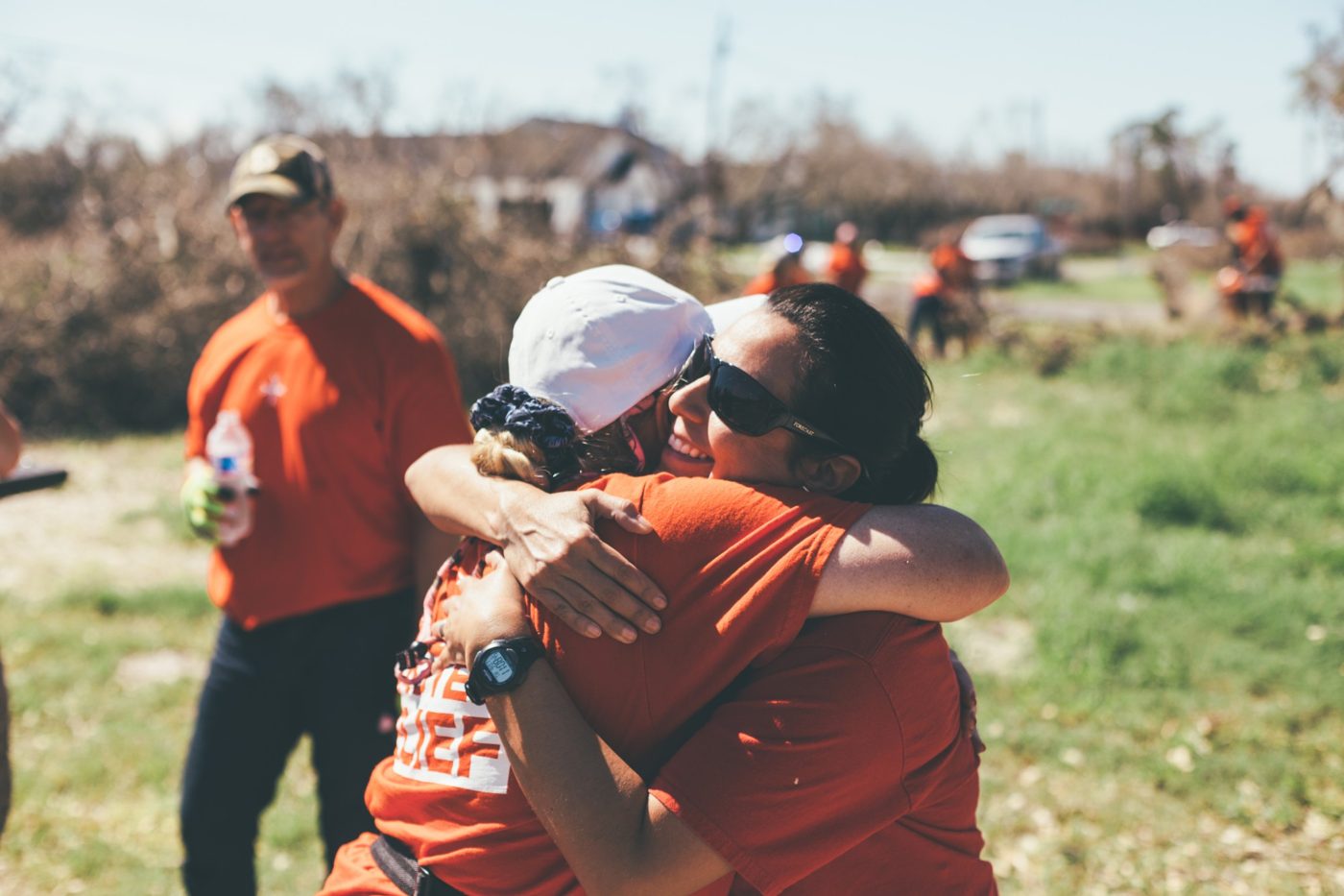 A disaster relief volunteer embraces a homeowner after a storm