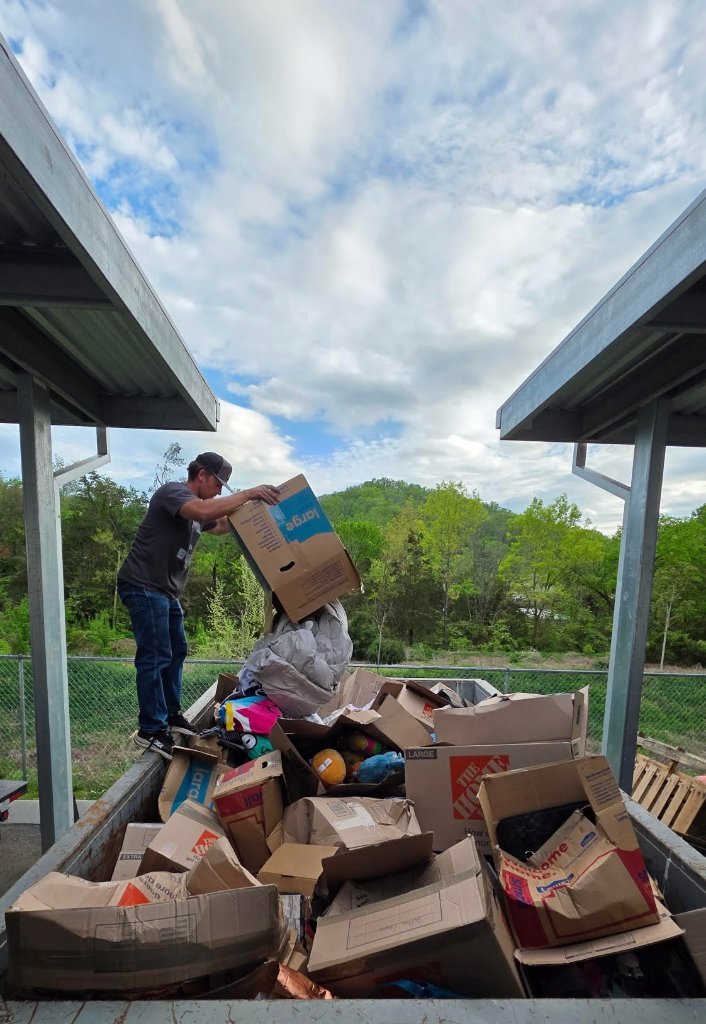 Cleanout Brothers worker loading junk into a dumpster