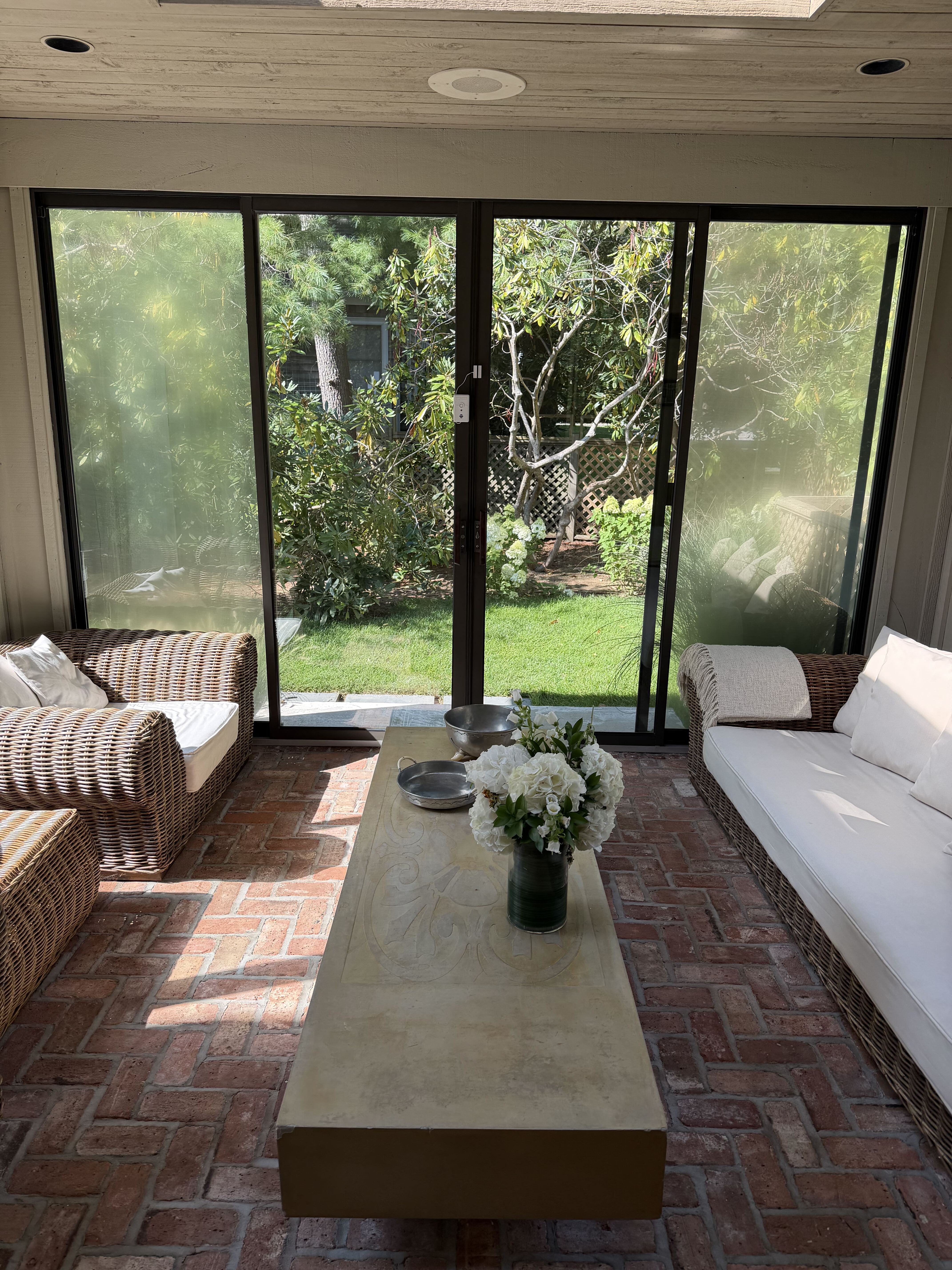 Sunroom with wicker seating and views into the garden