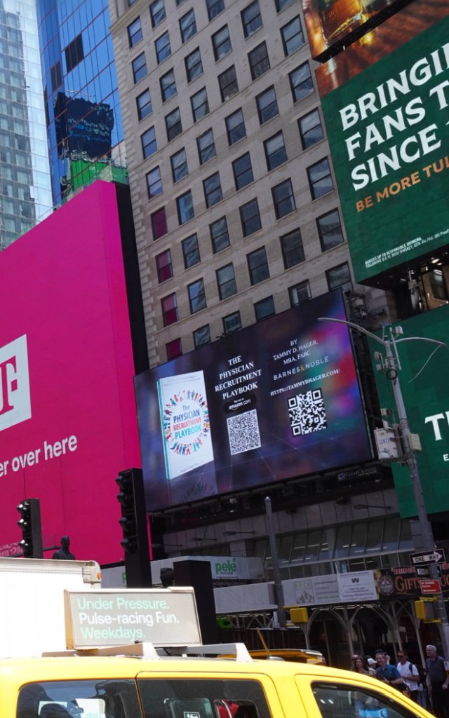 Wide view of the Times Square billboard showcasing the book and QR codes — May 19, 2026
