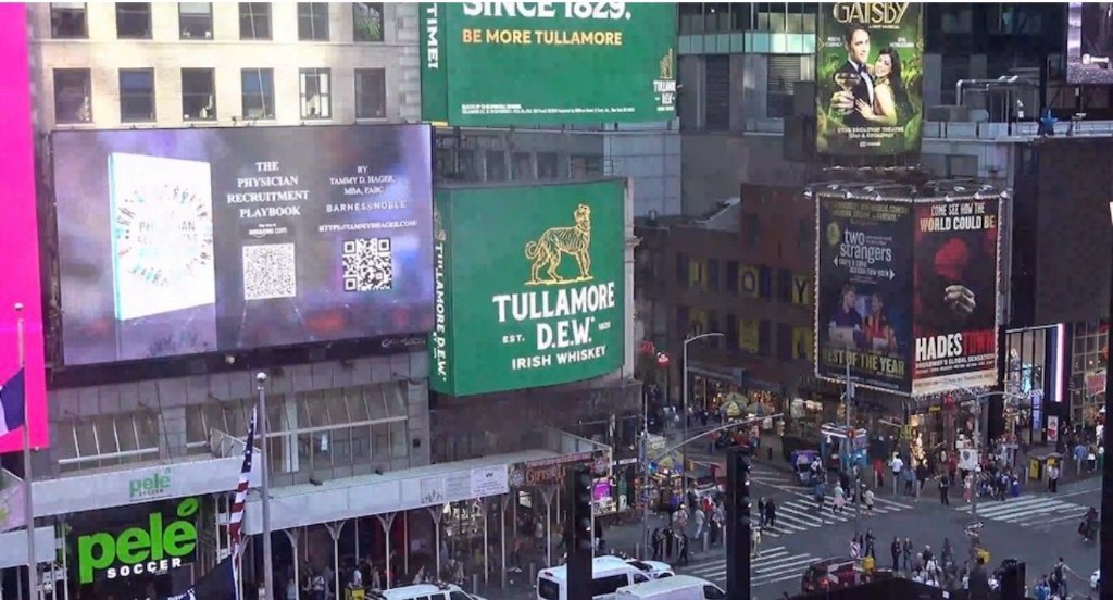The Physician Recruitment Playbook on the Times Square billboard with QR codes linking to Amazon and Barnes & Noble