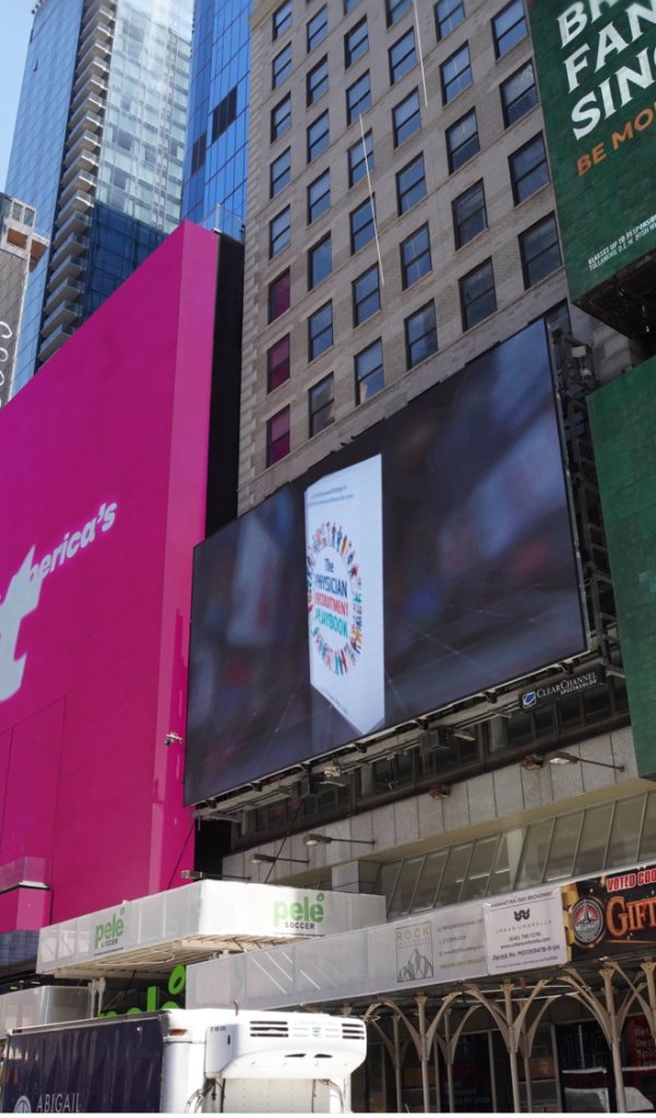 The book cover illuminated on the iconic Times Square screen — May 19, 2026