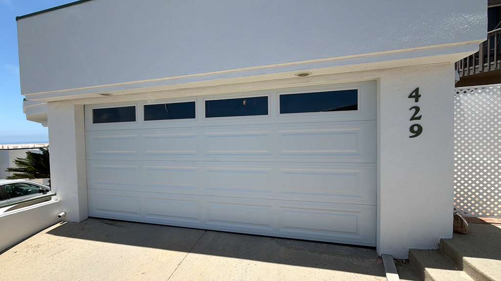 White double car garage door with glass windows installed in Los Angeles home