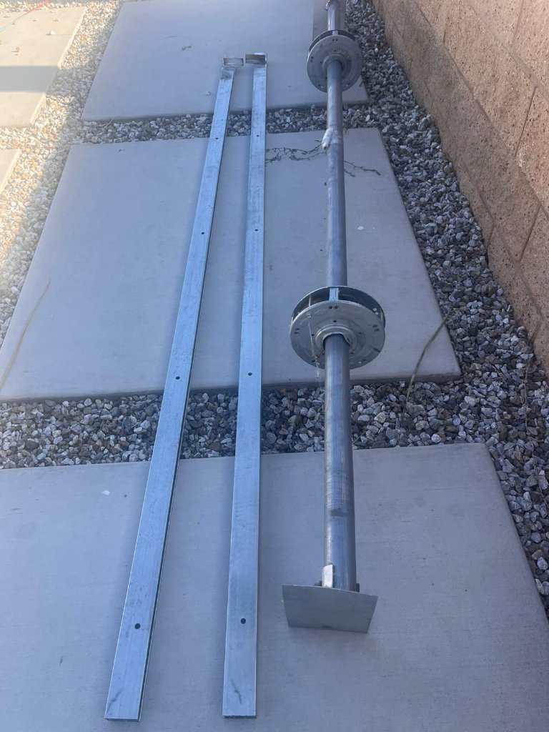 Garage door cable and hardware replacement Los Angeles New garage door torsion shaft and vertical tracks ready for installation during a cable and hardware repair in Los Angeles