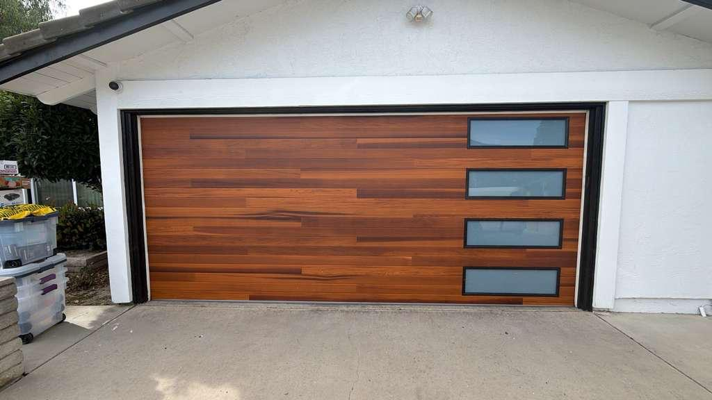 Modern wood garage door with horizontal slats and frosted glass window panels installed at a Los Angeles home by MSB Garage Door Repair
