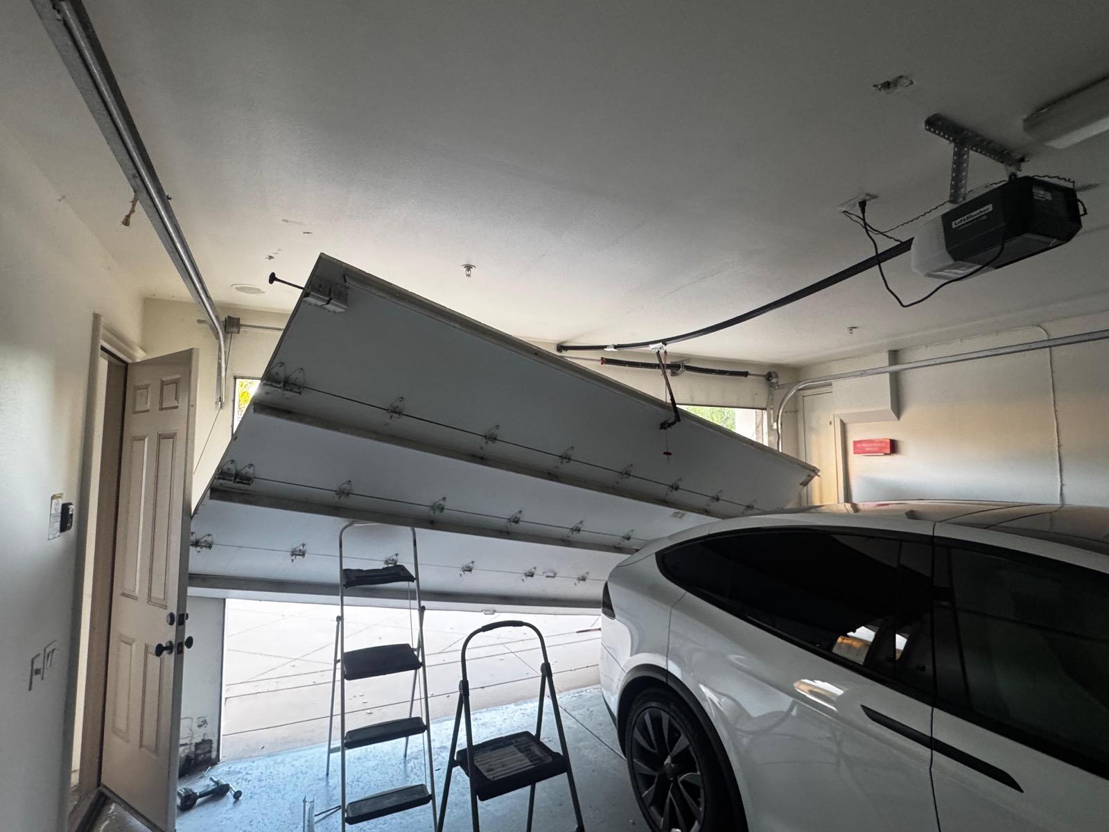 Garage door hanging dangerously off its track inside a Los Angeles garage before emergency repair by MSB