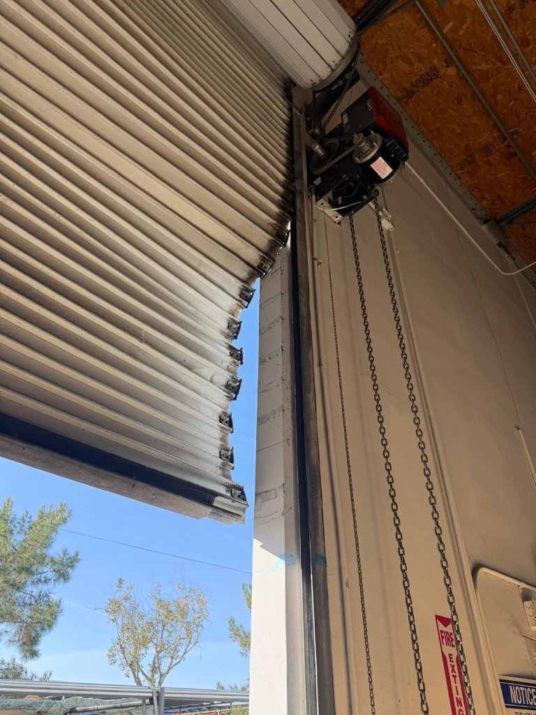 Corrugated steel door repair Los Angeles Wide view of corrugated steel commercial garage door repair job in progress at Los Angeles business